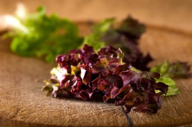 Mercan kırmızı yaprak marul üzerinde ahşap kereste