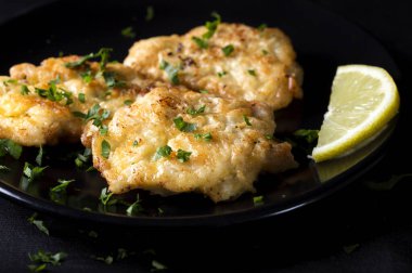 Koyu tabakta limonlu kızarmış tavuk şnitzel.