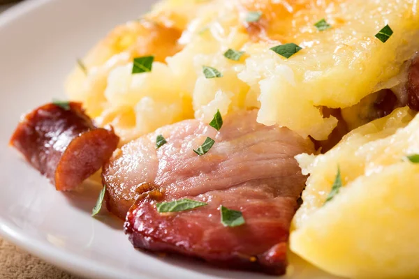 Peynir, pastırma ve sosis beyaz plaka üzerinde fırında patates