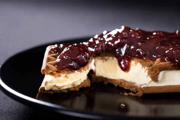 Dondurmalı sandviç ile çilek reçel koyu bir plaka üzerinde