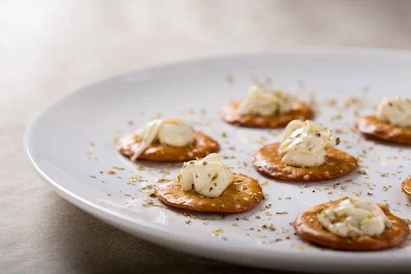 Kekik ile bir aperatif için beyaz tabakta krem peynirli kraker