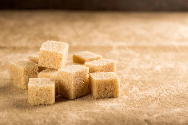 Kahverengi bir arka plan üzerinde kahverengi şeker kamışı küpleri