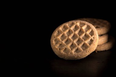 Tarçın ile siyah arka plan üzerinde yapılan bisküvi