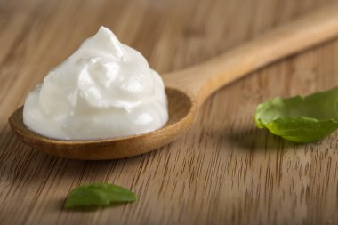 Tahta kaşık fesleğen yaprakları ile krem peynir