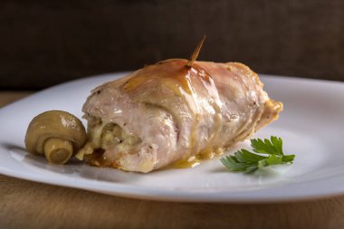 Kızarmış tavuk soslu beyaz plaka üzerinde peynir ve domuz pastırması ile rulo