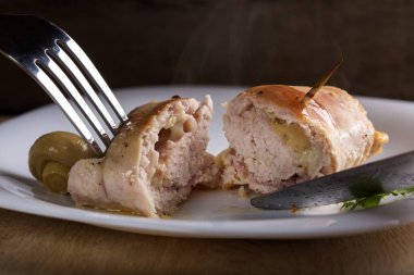 Kızarmış tavuk soslu beyaz plaka üzerinde peynir ve domuz pastırması ile rulo