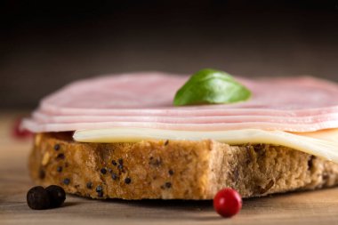 Salam, peynir ve fesleğen ahşap arka plan üzerine açık sandviçle, yakın çekim