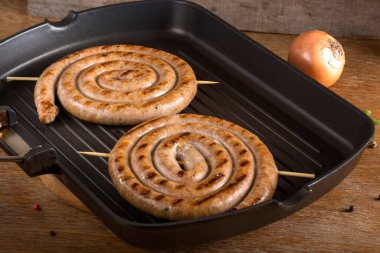 Bir tava üzerinde iki ızgara sosis