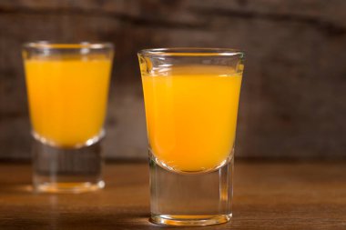 İki bardak votka portakal suyu ile ahşap arka plan üzerinde ateş