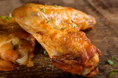 Tahtadaki kızarmış tavuk kanatlarını taze maydanozla kapat.