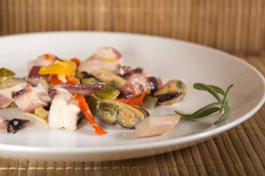 bir mürekkep balığı, ton balığı filetosu, midye et ile deniz ürünleri salatası