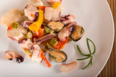 bir mürekkep balığı, ton balığı filetosu, midye et ile deniz ürünleri salatası