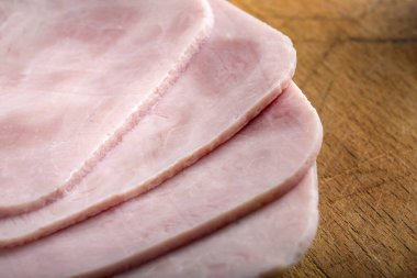 Ahşap zeminde taze jambon dilimleri.