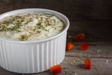 Yoğurttan, şifalı otlardan ve ahşap bir masada kasede kara biberden yapılan sos.