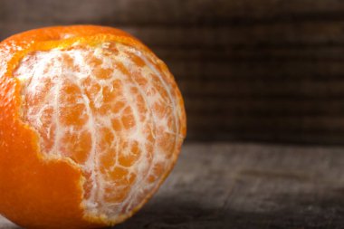 Ahşap arka planda soyulmuş bir portakalı fotokopi aletiyle kapat.