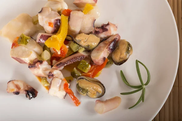 bir mürekkep balığı, ton balığı filetosu, midye et ile deniz ürünleri salatası