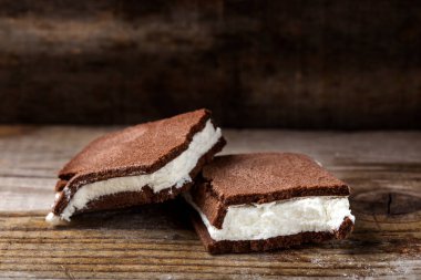 Tahta arka planda süt ve yoğurt kreması dolu kırık bir pastanın kapağını kapat.