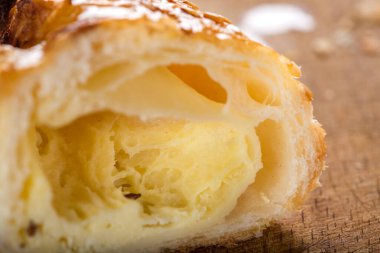 Tahta zemin üzerine bal ve susam tohumu sürülmüş bir peynirli böreğin içi.