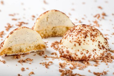 İki vanilyalı inci şeker, ikiye bölünmüş ve beyaz arka planda siyah çikolata rendelenmiş.