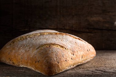 Eski ahşap arka planda bir fırınlanmış ekmek.