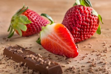 Çikolata ve çilek ahşap arka planda.