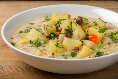 Mantarlı patates çorbası ve beyaz kasede ekşi krema.