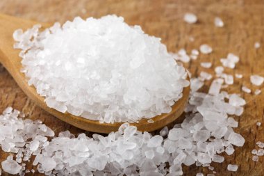 Ahşap zemin üzerinde ahşap kaşıkla deniz tuzu yakın