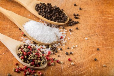 Tahta kaşıklar, deniz tuzu ve ahşap zemin üzerinde biber ve fotokopi alanı. Sığ noktalı Macro.