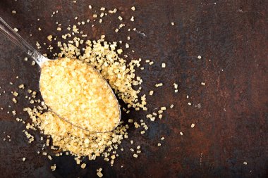 Koyu arkaplanda kaşık içinde kahverengi şeker