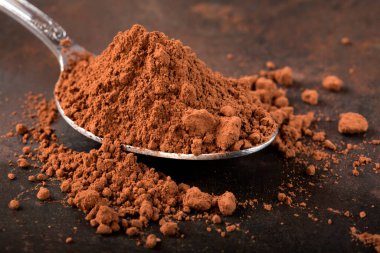 Paslı arka planda kakao dolu kaşık