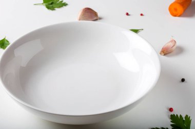 Sebze ve otlarla dolu boş beyaz kase.