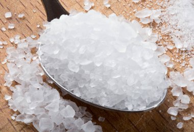 Ahşap zemin üzerinde ahşap kaşıkla deniz tuzu yakın