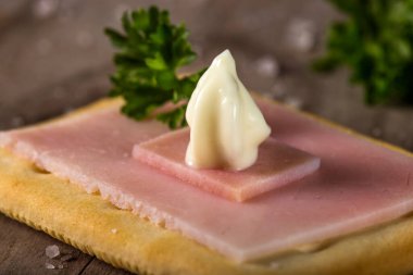 Jambonlu kraker ve ahşap üzerine tuz ve maydanoz sosu.