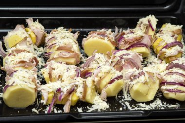 Soğanla doldurulmuş patates, jambon ve pişirilmeye hazır beyaz peynir.