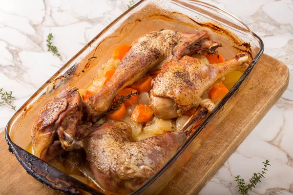 Tepside kızarmış tavuk ve havuç ve soğan.