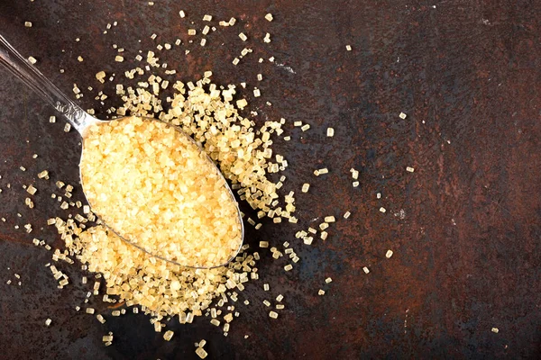 Koyu arkaplanda kaşık içinde kahverengi şeker