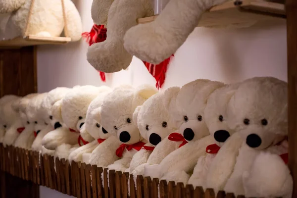 Tahta bir rafta beyaz oyuncak ayılar