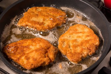 Sıcak tavada sosisli şnitzel kızartıyorum.