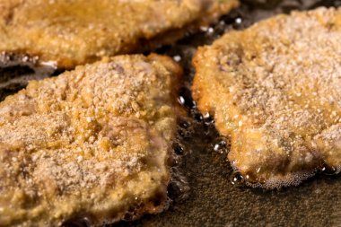 Sıcak tavada sosisli şnitzel kızartıyorum.