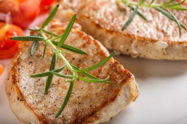 Kızarmış domuz pirzolası ve yakın plan tabakta kızartılmış sebze. 