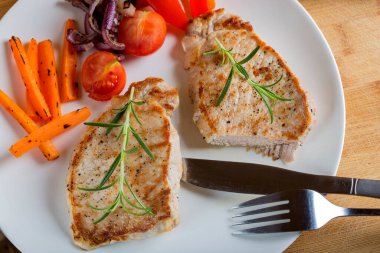 Kızarmış domuz pirzolası ve yakın plan bir tabakta kızarmış sebze. yatay