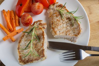 Kızarmış domuz pirzolası ve yakın plan bir tabakta kızarmış sebze. yatay