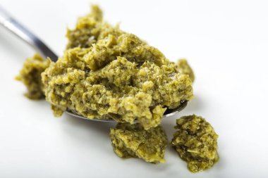 Beyaz arka planda yeşil İtalyan pesto kaşığı