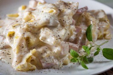 Tortellini ve füme jambon, mantar ve ekşi krema soslu ravioli.