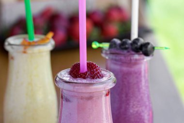 Çilek, kızılcık ve yoğurtla harmanlanmış mango içeren taze organik içerikli üç meyveli milkshake.