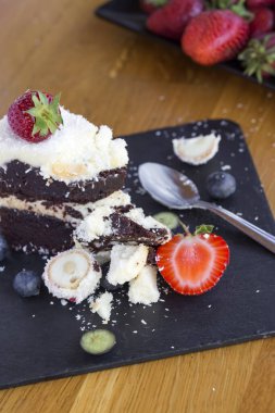 Beyaz ve siyah çikolata, meyve ve hindistan cevizli nefis çikolatalı kek yemek.