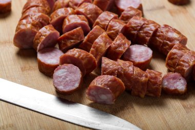 Ahşap kesme tahtasının üzerinde domuz sosisi dilimleri - yakın görüş