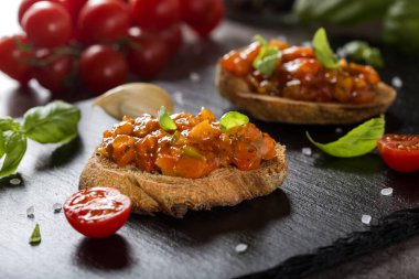 Domatesli, sarımsaklı, kırmızı biberli ve fesleğenli ev yapımı İtalyan antipasto. Yakın çekim.