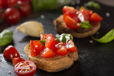 Domatesli, sarımsaklı ve fesleğenli İtalyan antipasto. Yakın görüş.