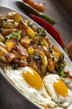 Yumurta ve patates kızartması, küçük parça domuz eti, soğan ve sarımsak tabakta - yakın görüş